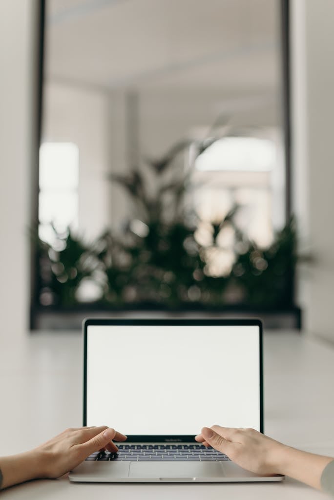 A minimalist workspace featuring an open laptop in a bright, serene indoor setting.